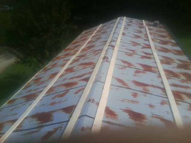 Rusted metal roof panels with new wood purlins before replacement — Storm Damage Roof Repair in Wolf Creek by Roofing Brothers