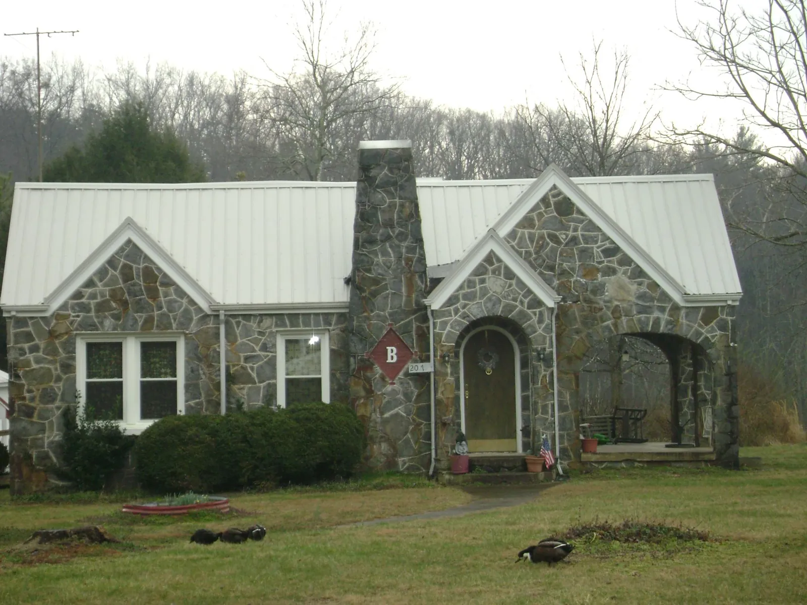 White metal roof on a stone cottage with steep gables in Wolf Creek
